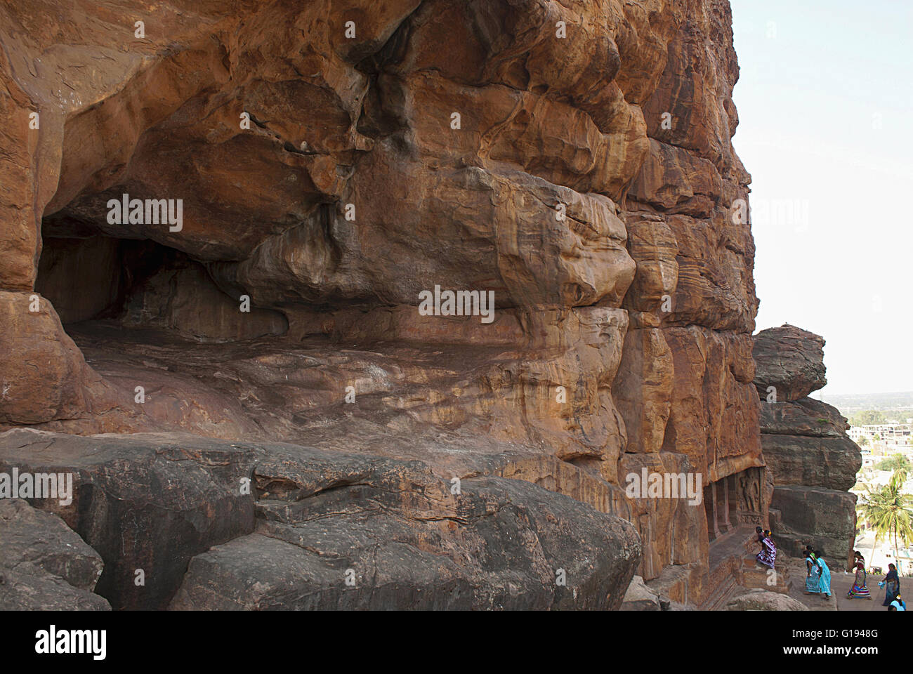Vue générale, les grottes de Badami, Karnataka, Inde. Grotte inachevé sur la gauche, et les touristes entrant dans la grotte 2 ci-dessous. Banque D'Images