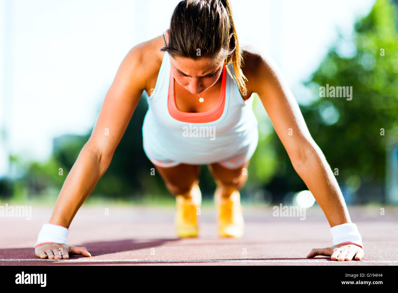 L'accent young Beautiful woman faisant push-ups à l'extérieur sur une chaude journée d'été Banque D'Images