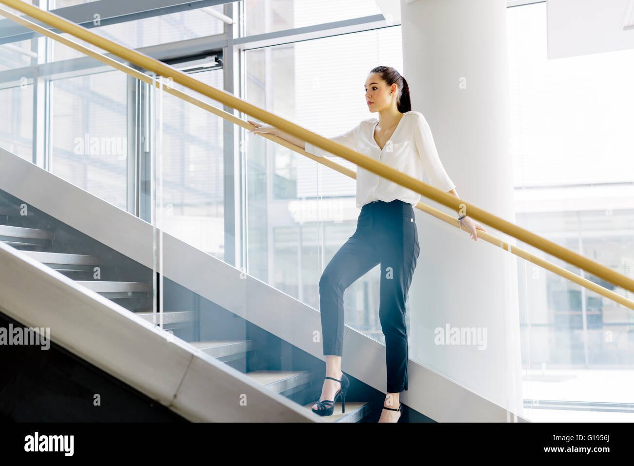 Businesswoman on stairs in a modern office Banque D'Images