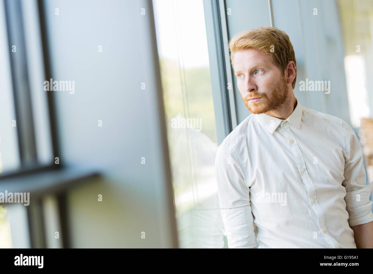 Portrait d'un homme debout près de la fenêtre Banque D'Images