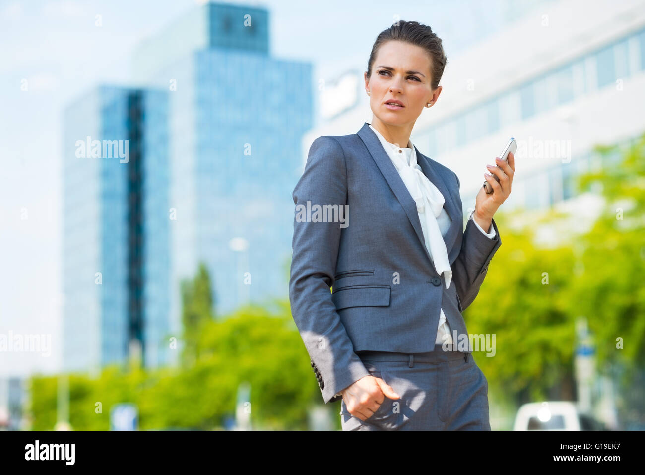 Dans les tendances d'affaires ultra-moderne. Business Woman with cell phone in district bureau moderne Banque D'Images