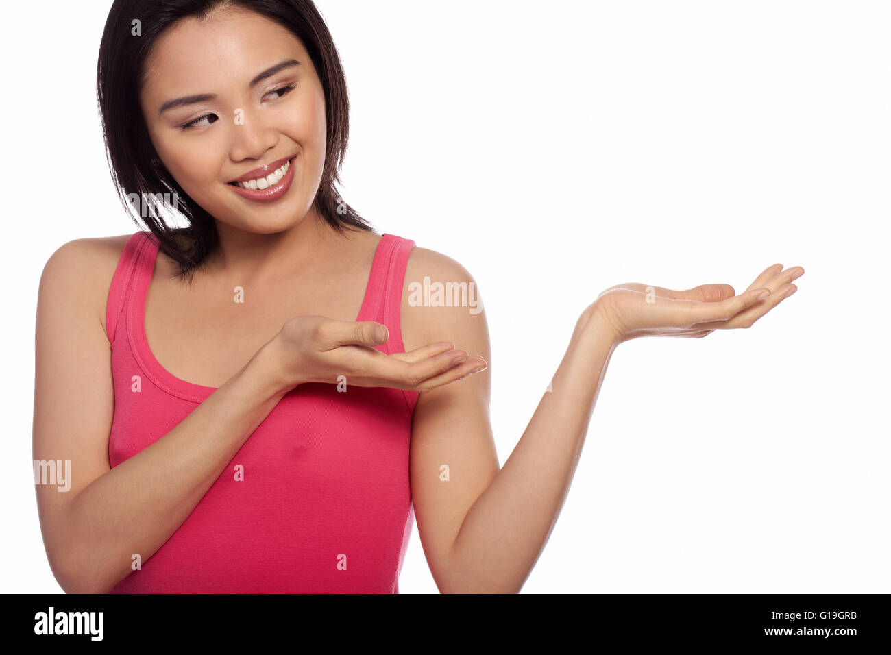 Smiling Asian woman holding out sa paume pour votre placement de produit pour la publicité isolated on white Banque D'Images
