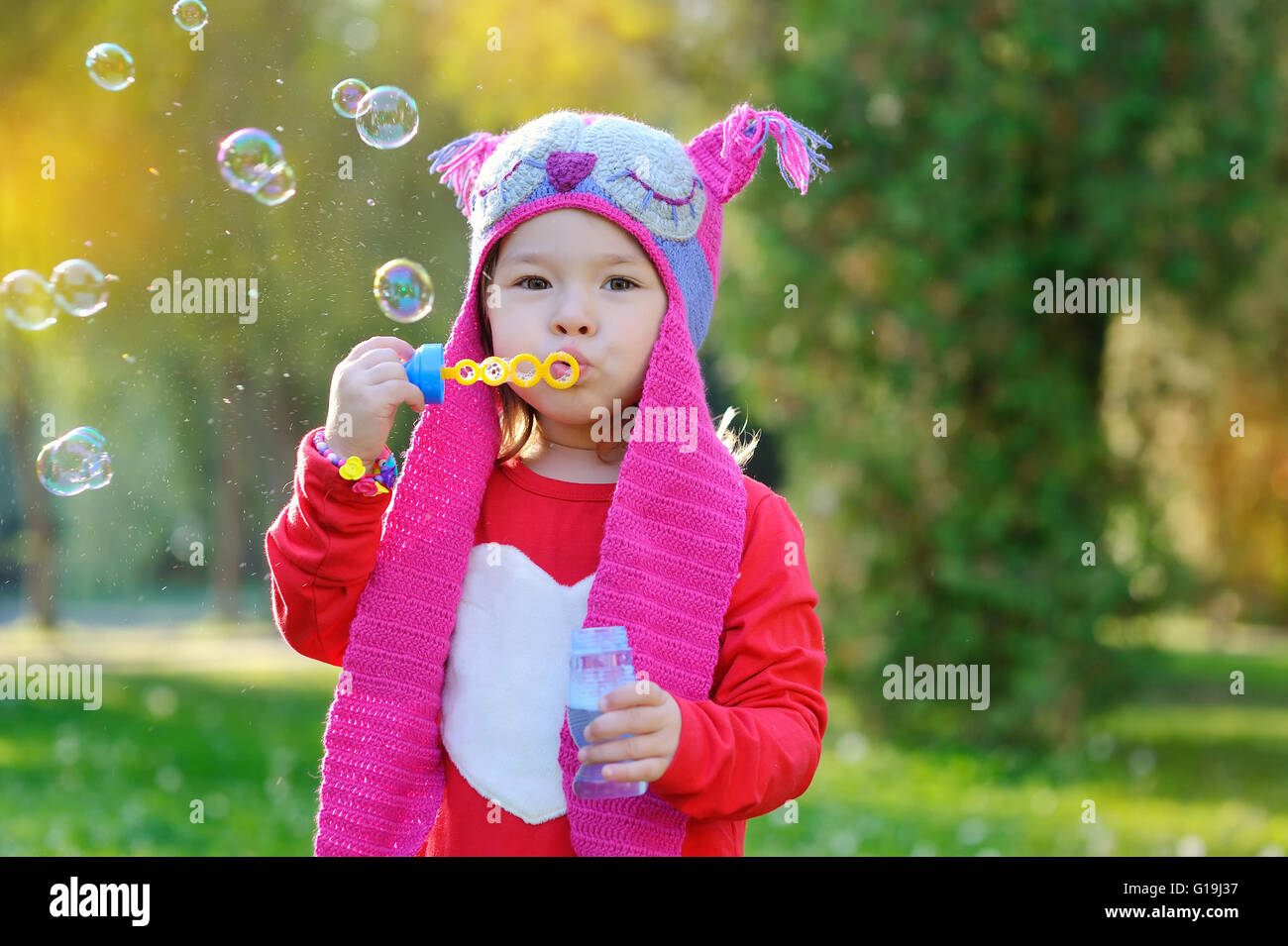 Fille avec des bulles de savon dans un tricot fait main chapeau Banque D'Images