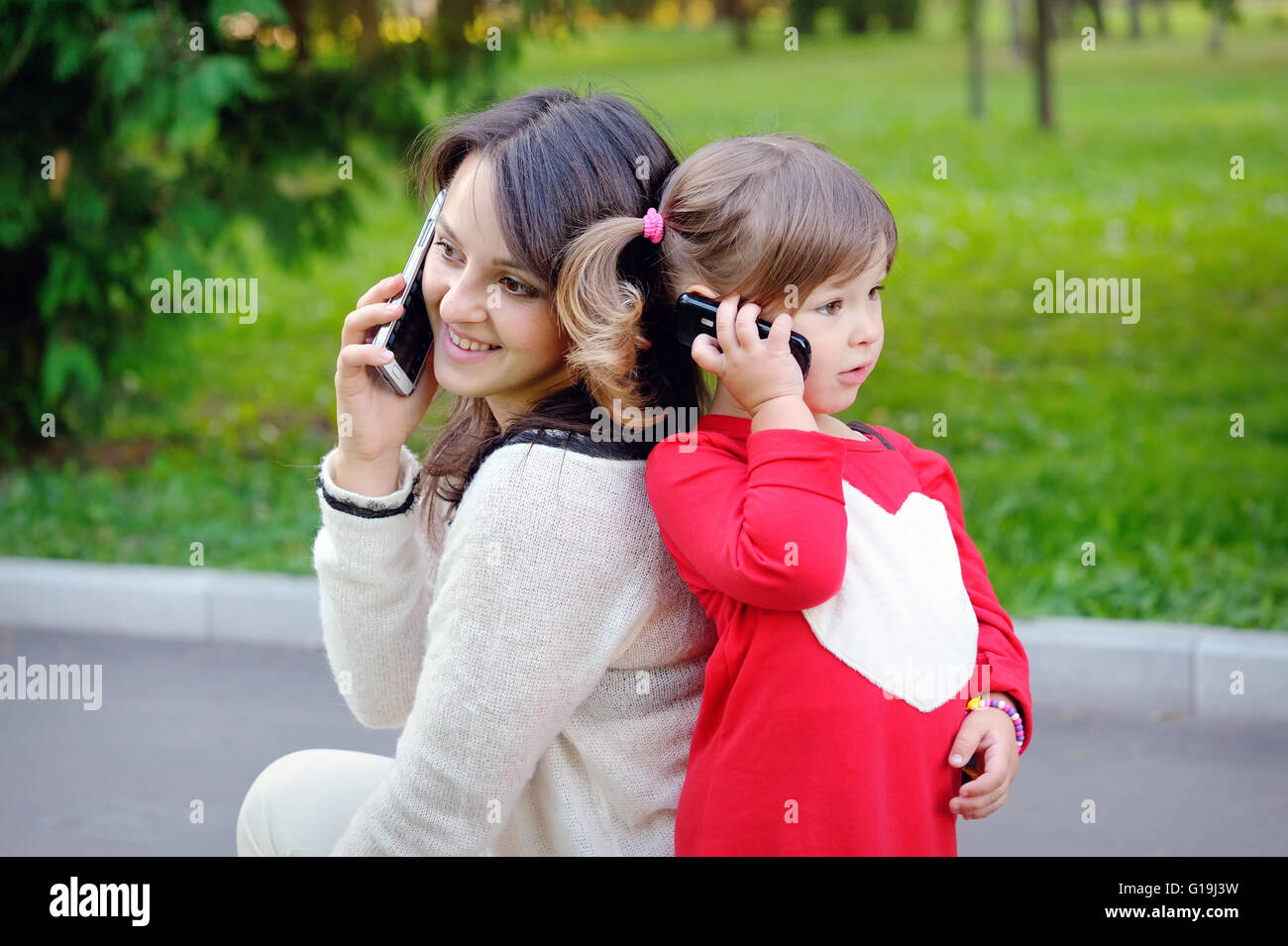 La mère et l'enfant à parler au téléphone Banque D'Images