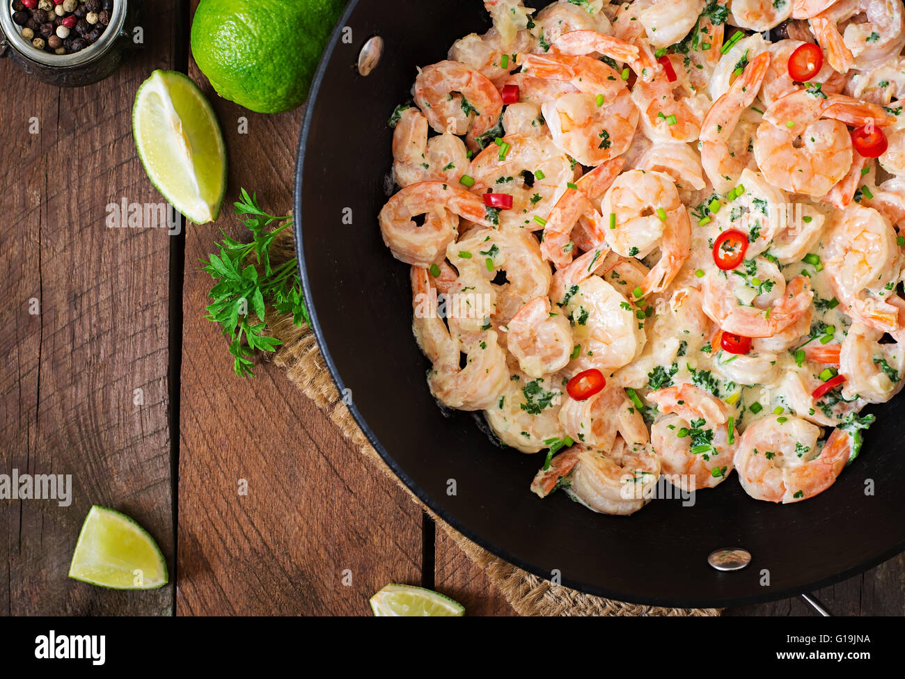 Crevettes en sauce à l'ail crème de persil et citron dans une poêle
