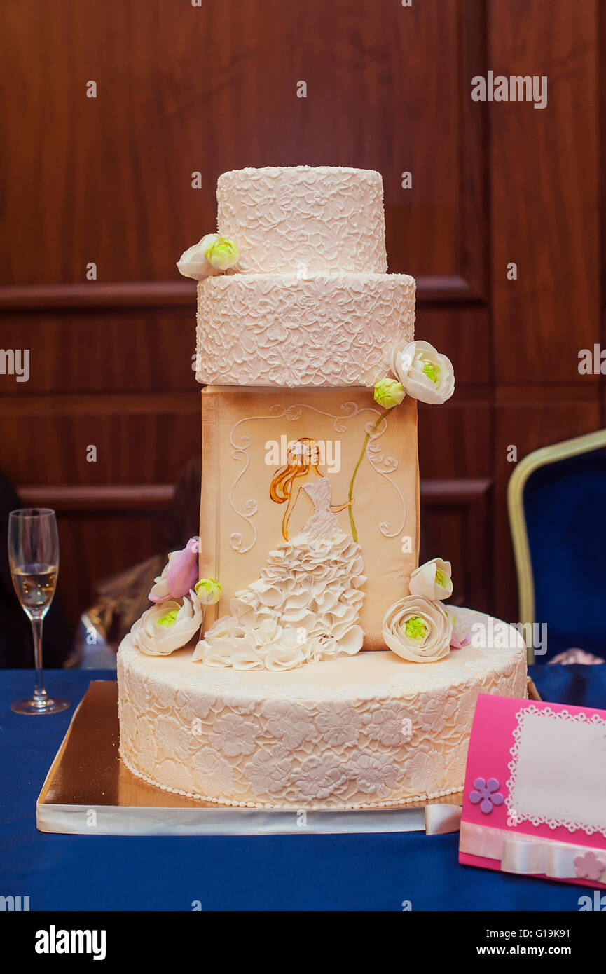 Un gâteau de mariage blanc multi de niveau sur une base en argent et rose rose ... Banque D'Images