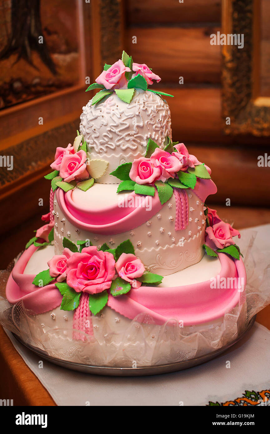 Gâteau de mariage rose et blanc sur une table de dessert Banque D'Images