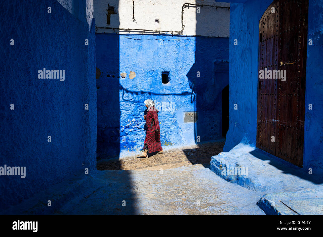 Chefchaouen, Maroc - 10 Avril 2016 : une femme marche dans une rue de la ville de Chefchaouen au Maroc. Banque D'Images