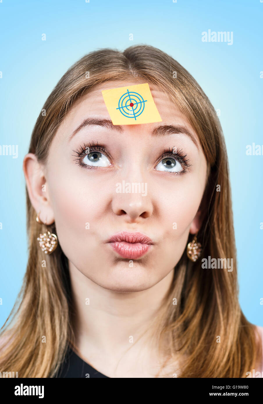 Un portrait d'une jeune femme confuse avec un post-it sur son front Banque D'Images