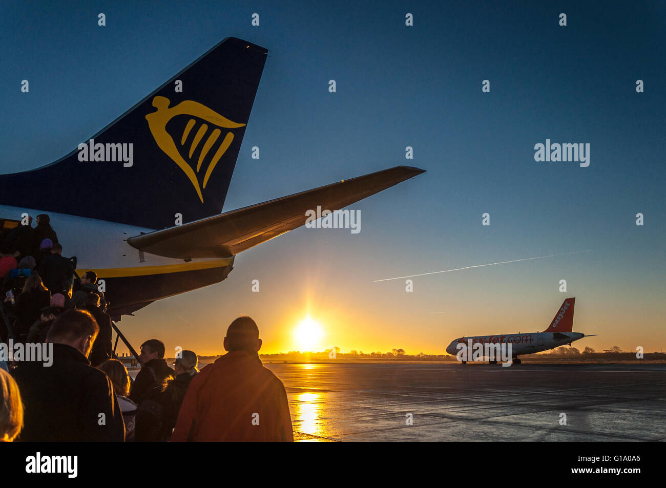 Les passagers à bord d'un vol Ryanair au lever du soleil dans l'aéroport de Bristol, Angleterre, Royaume-Uni Banque D'Images