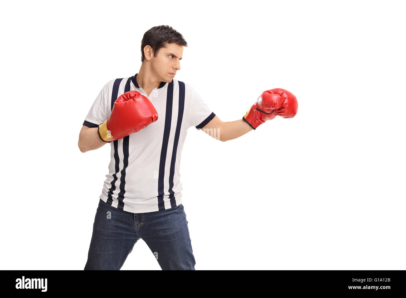 Jeune homme en colère avec des gants de boxe rouge isolé sur fond blanc Banque D'Images