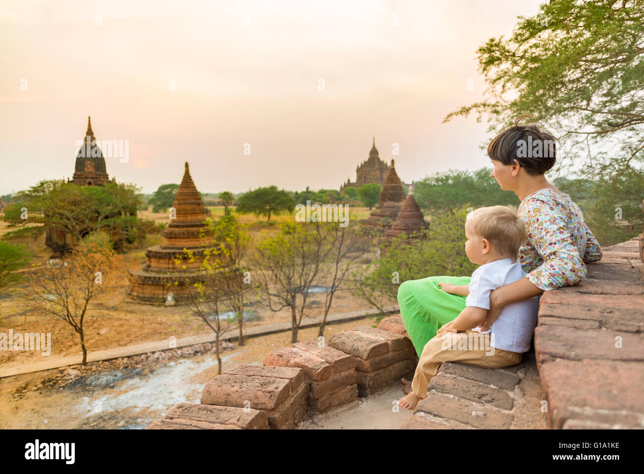 Mère et enfant sont à la coucher du soleil à partir d'une pagode à Bagan. Le Myanmar. Banque D'Images