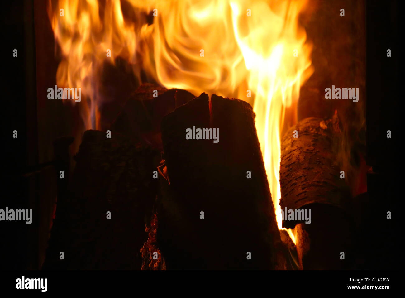 Crête de flamme sur la combustion du bois dans cheminée close up Banque D'Images