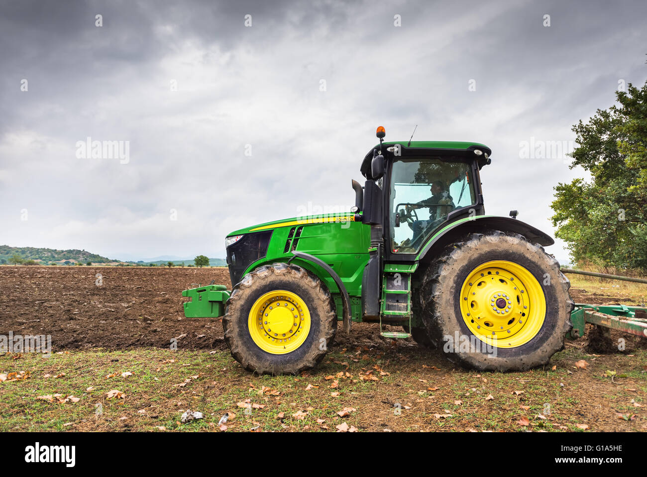 Karlovo, Bulgarie - Août 22th, 2015 : labourer un champ avec John Deere 6930 tracteur. John Deere 8100 a été fabriqué en 1995- Banque D'Images