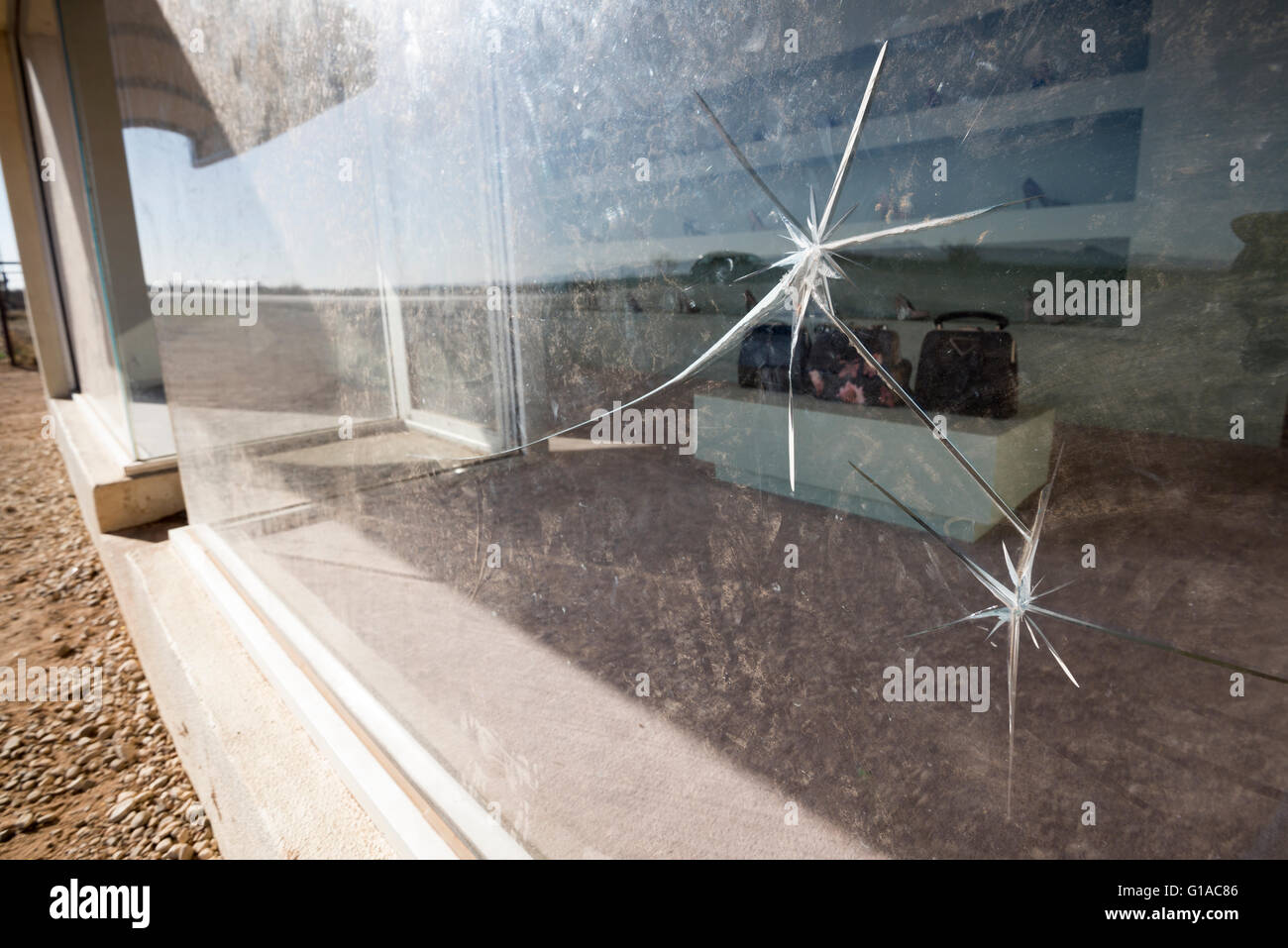 Fissures dans la fenêtre avant de Prada Marfa, une installation artistique près de Valentine, Texas. Banque D'Images