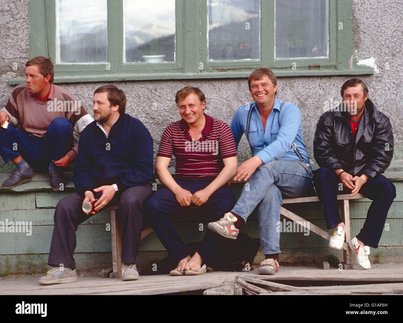 Les hommes de vous détendre sur banc extérieur ; EGVEKINOT, région de Magadan, ville côtière SUR LA MER DE BÉRING ; FÉDÉRATION DE RUSSIE Banque D'Images