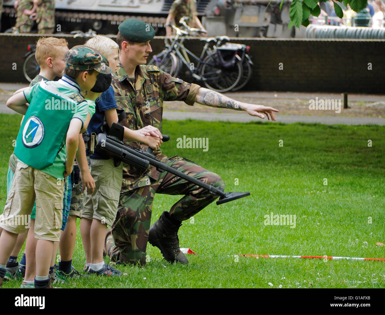 Soldat de l'armée royale néerlandaise montrant enfants garçons enfants comment fonctionne un détecteur de métal, parc Valkenberg, Breda, Pays-Bas Banque D'Images