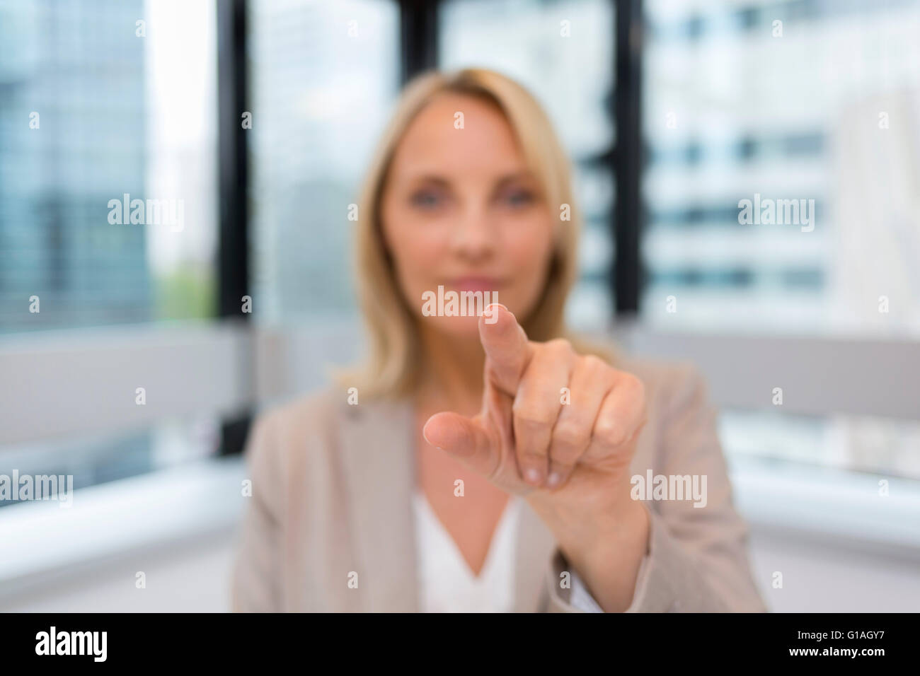 Doigt femme poussant un écran numérique d'arrière-plan du bureau. Banque D'Images