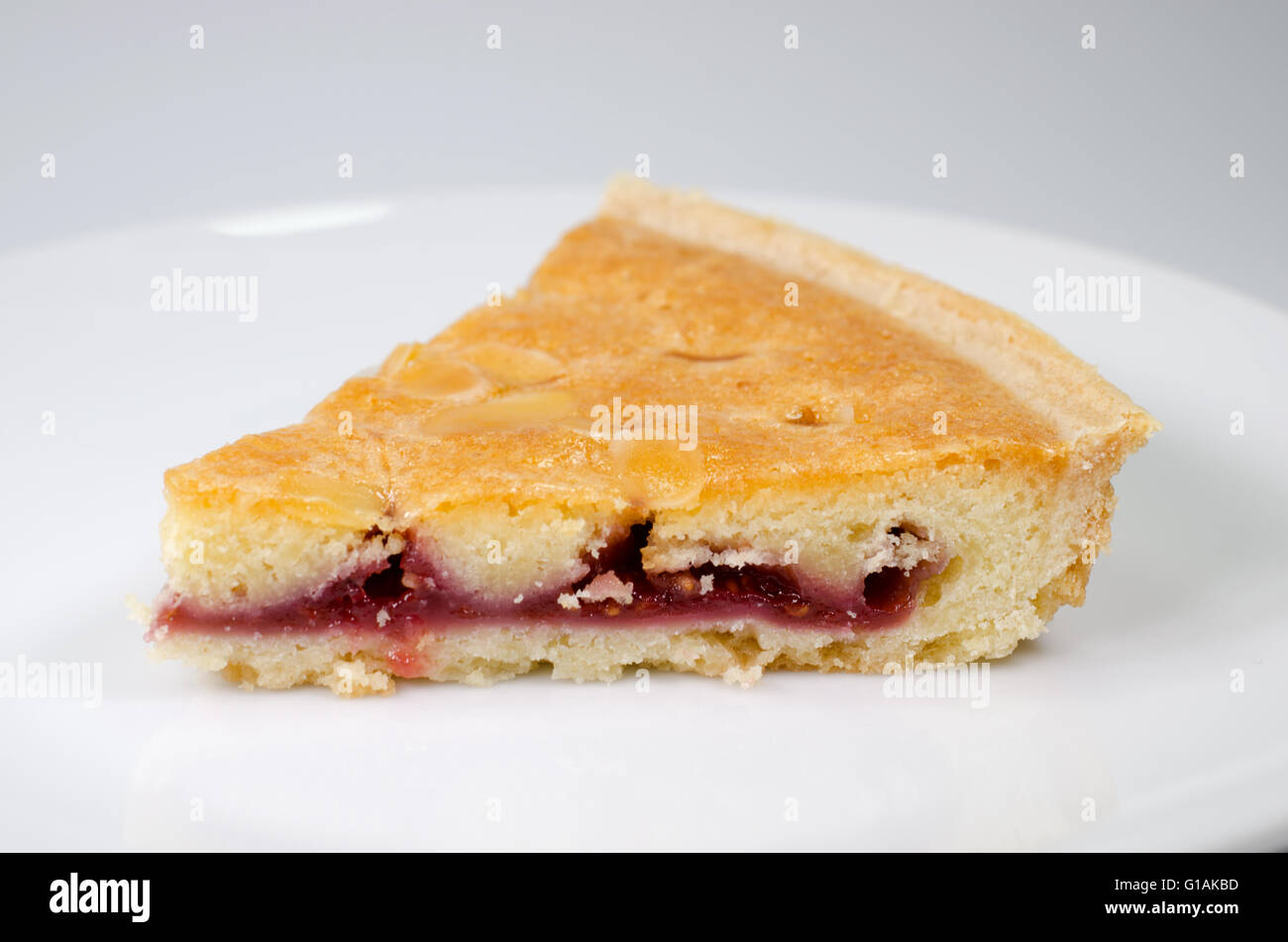 Tranche de bakewell tart on white plate Banque D'Images