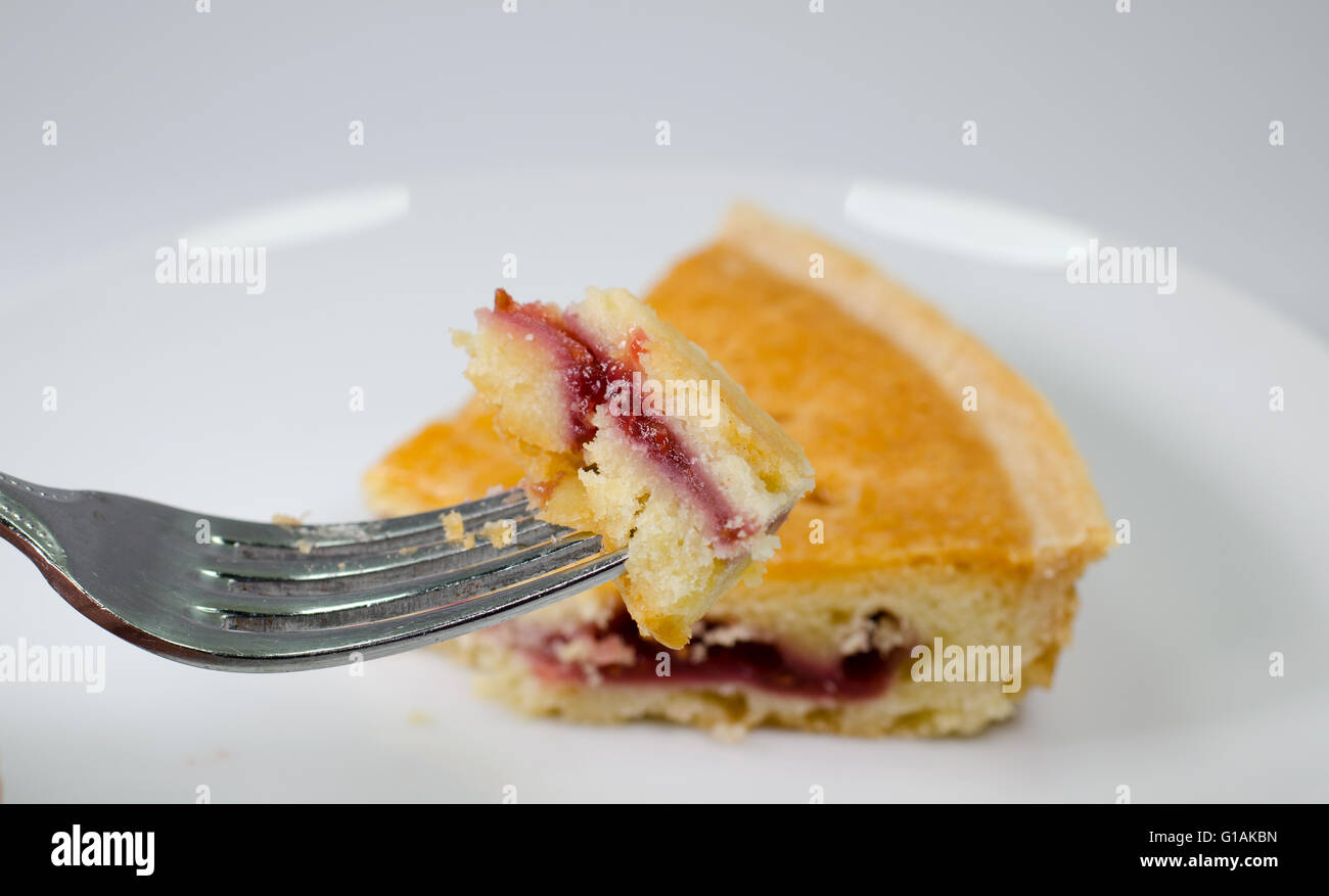 Gorgée de bakewell tart sur fourche slice avec en arrière-plan Banque D'Images