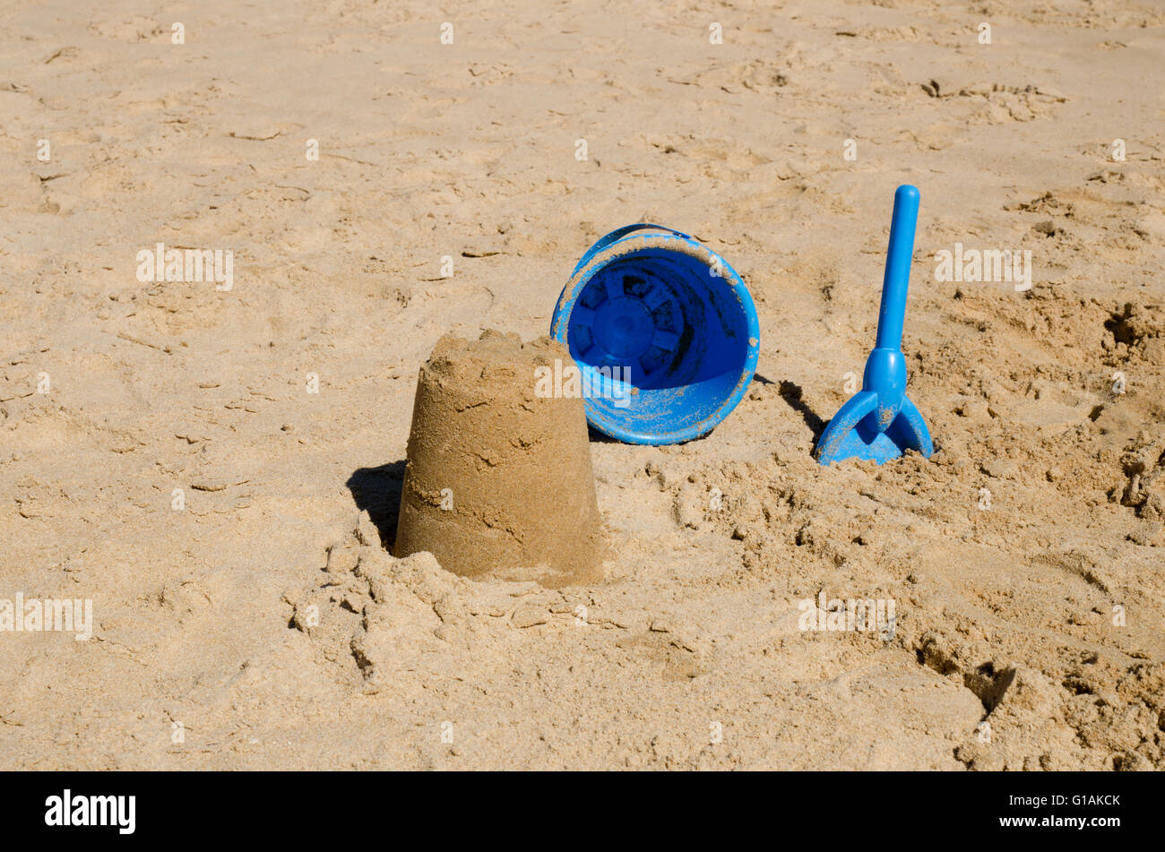 Sandcastle, godet et spade on beach Banque D'Images