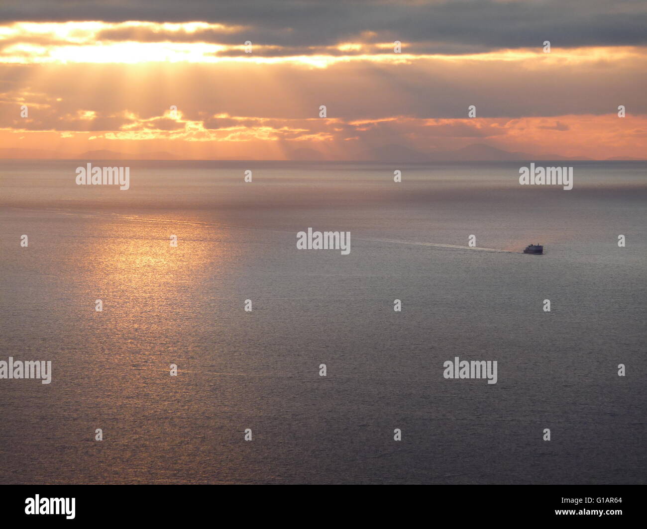Bateau sillonnant à travers la mer des Hébrides au coucher du soleil Banque D'Images