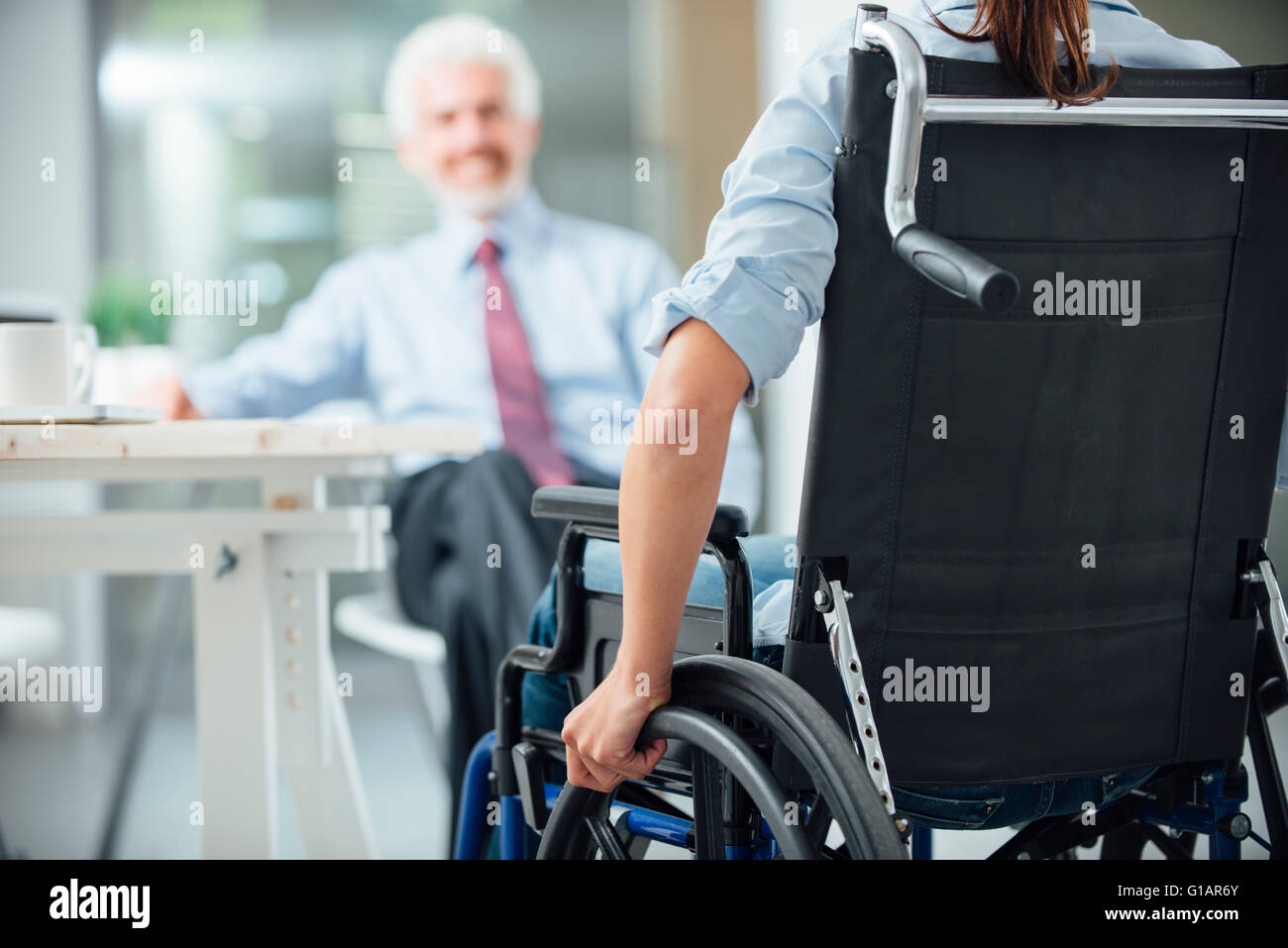 Femme handicapée ayant une réunion d'affaires avec un homme d'affaires vue arrière, selective focus Banque D'Images