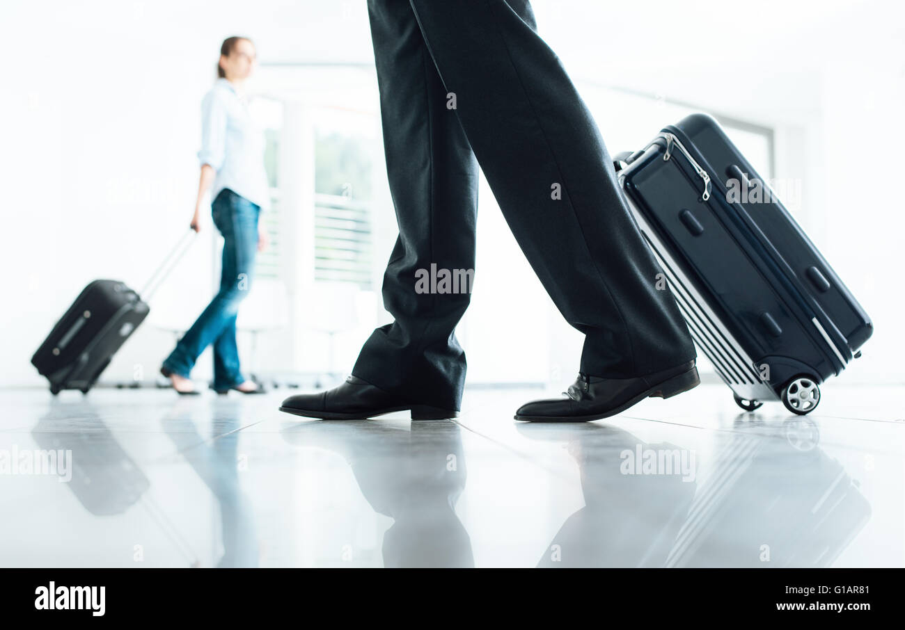 Balades au terminal passagers avec bagages valise trolley, méconnaissable et personnes Banque D'Images
