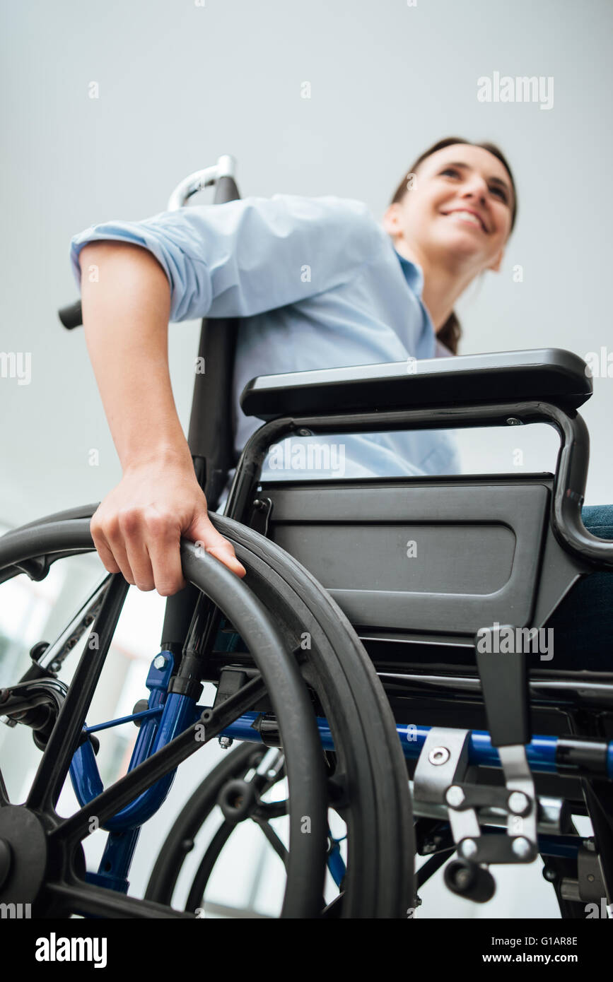 Young woman in wheelchair smiling et à l'écart, le handicap concept Banque D'Images