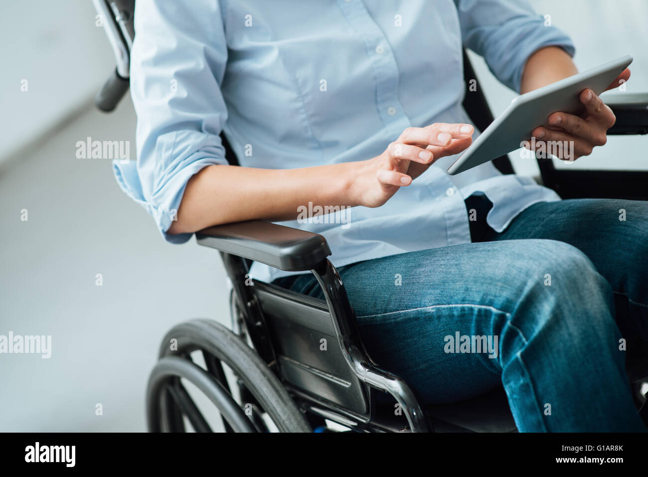Woman in wheelchair méconnaissables à l'aide d'un écran tactile numérique, d'invalidité et d'assistance concept Banque D'Images