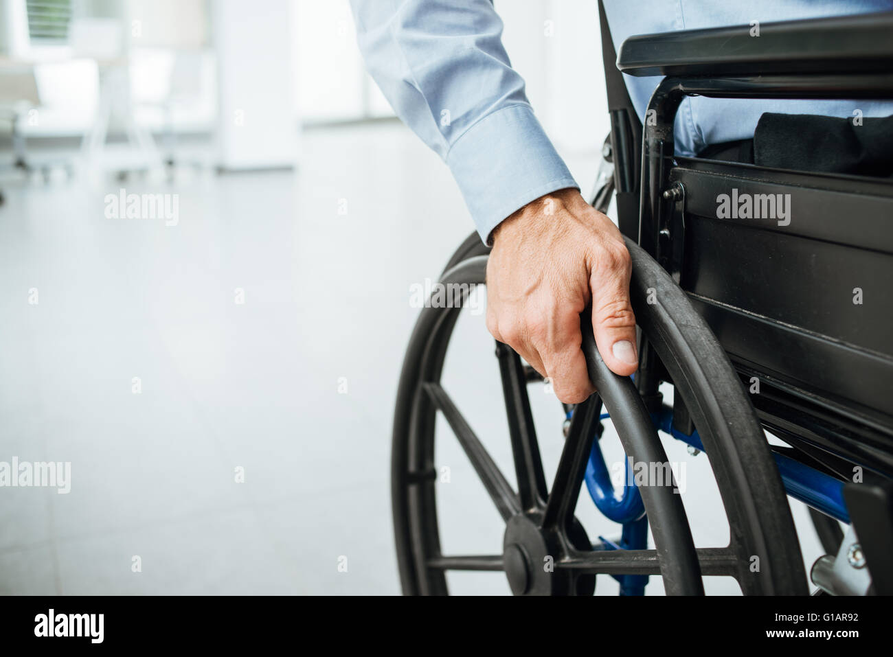 Homme d'affaires en fauteuil roulant, sur la roue à main close up, cabinet intérieur sur l'arrière-plan Banque D'Images