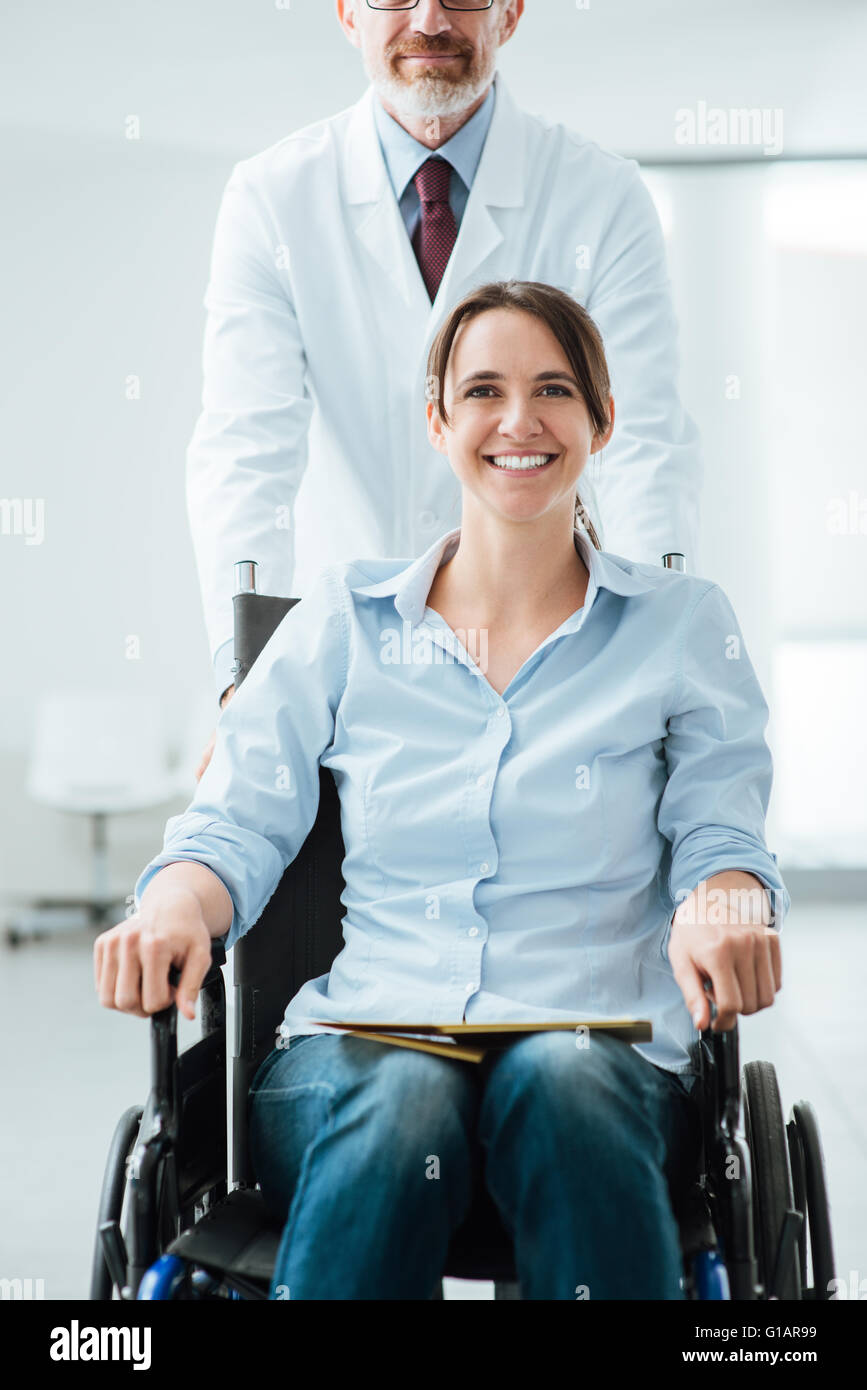 Médecin en poussant un female patient in wheelchair, concept d'aide et de soins Banque D'Images