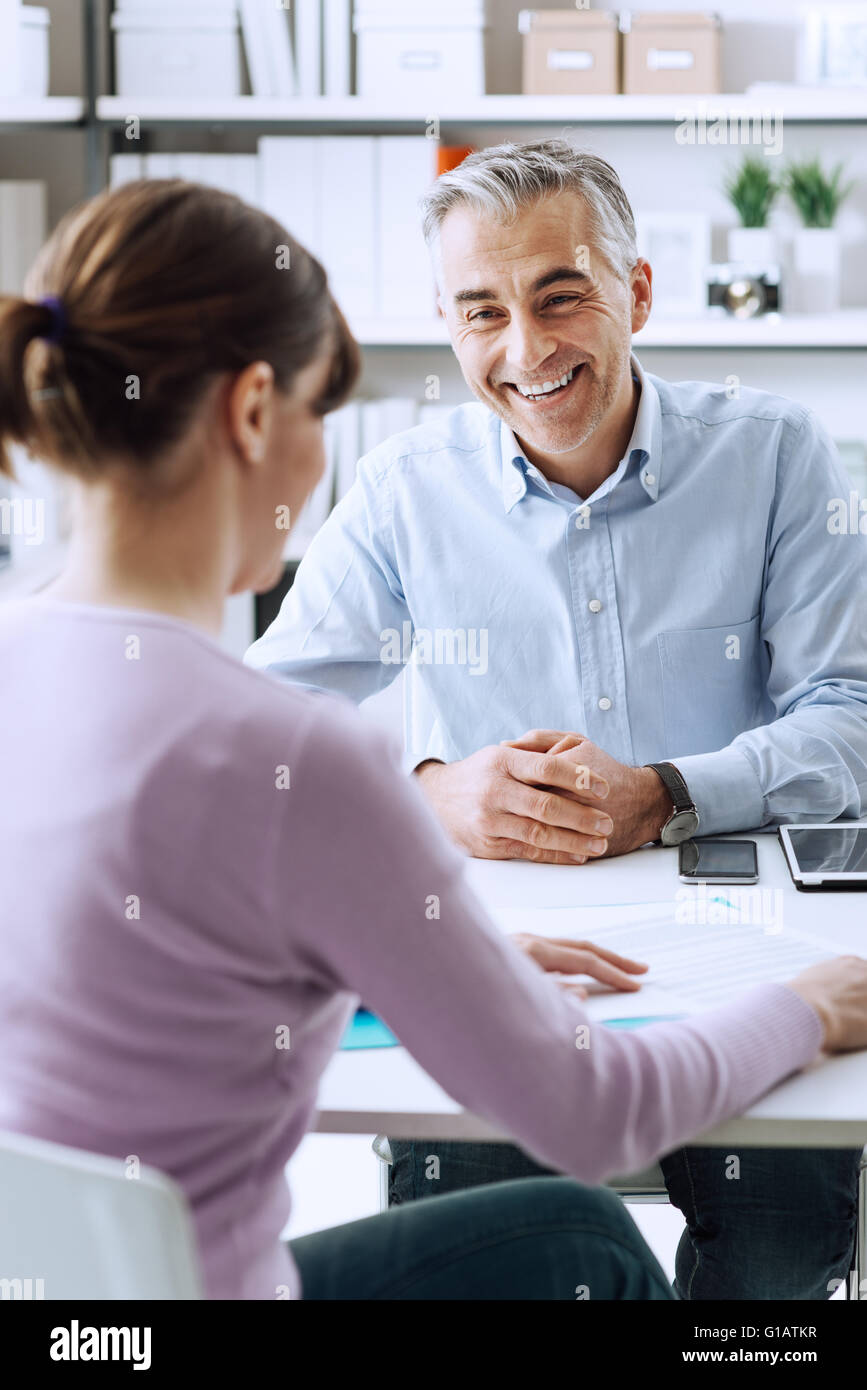 Homme mature et jeune femme ayant une réunion d'affaires dans le bureau, ils discutent ensemble Banque D'Images Homme mature et jeune femme ayant une réunion d'affaires dans le bureau, ils discutent ensemble Banque D'Images