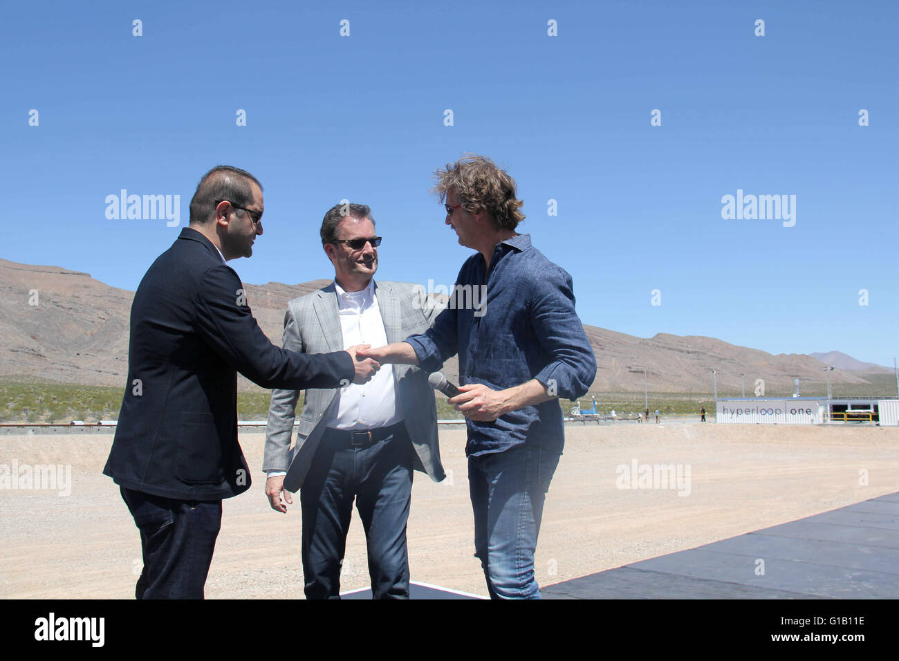 Las Vegas, Nevada, USA. Le 11 mai, 2016. L'Hyperloop co-fondateurs Shervin Pishevar (L), Brogan BamBrogan(R) et chef Rob Lloyd(C) félicite l'autre après un test à l'air libre de propulsion de l'Hyperloop la technologie des transports, au Nevada, États-Unis, 11 mai 2016. Un Hyperloop étapes la première démonstration publique d'un élément clé de la mise en route du train futuriste du concept qui pourrait un jour les passagers des ferries à près de des vitesses supersoniques. © Guo Shuang/Xinhua/Alamy Live News Banque D'Images
