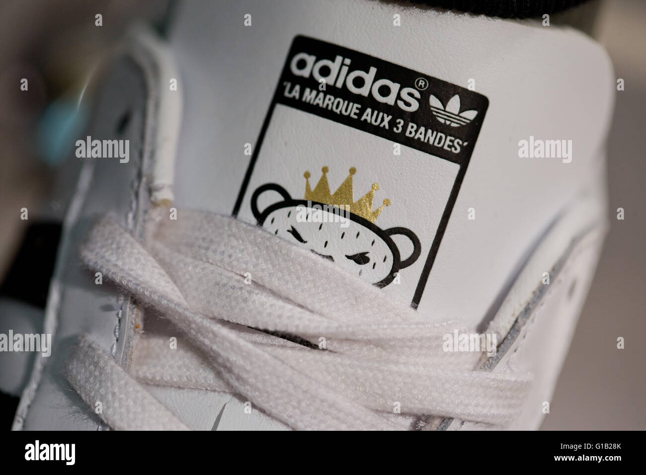 Fürth, Allemagne. 12 mai, 2016. Le logo de la société d'adidas et le  lettrage de langue française 'La marque aux 3 bandes" (lit. La marque aux  trois bandes) vu sur une chaussure