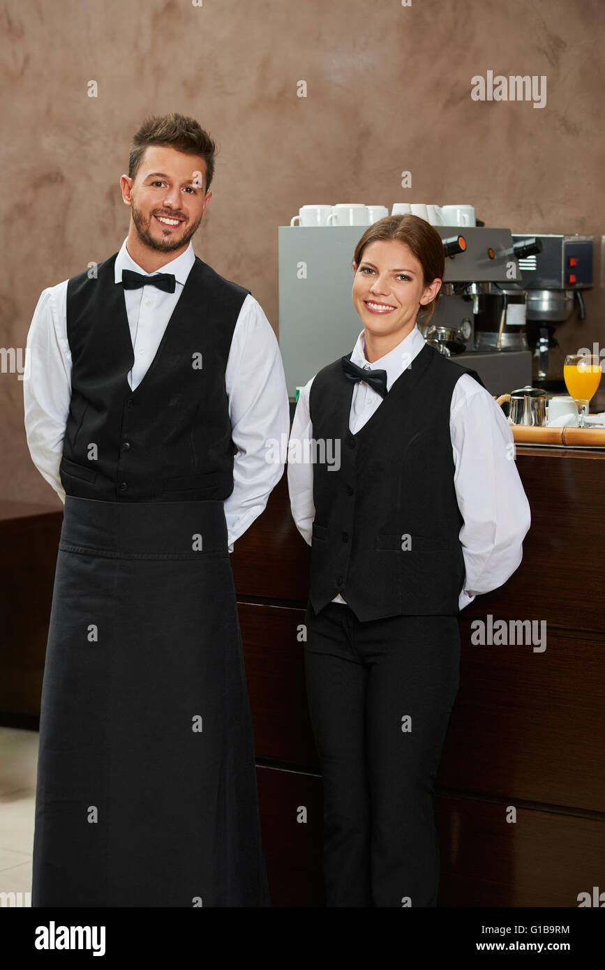 Smiling waiter et serveuse en uniforme dans un restaurant Banque D'Images