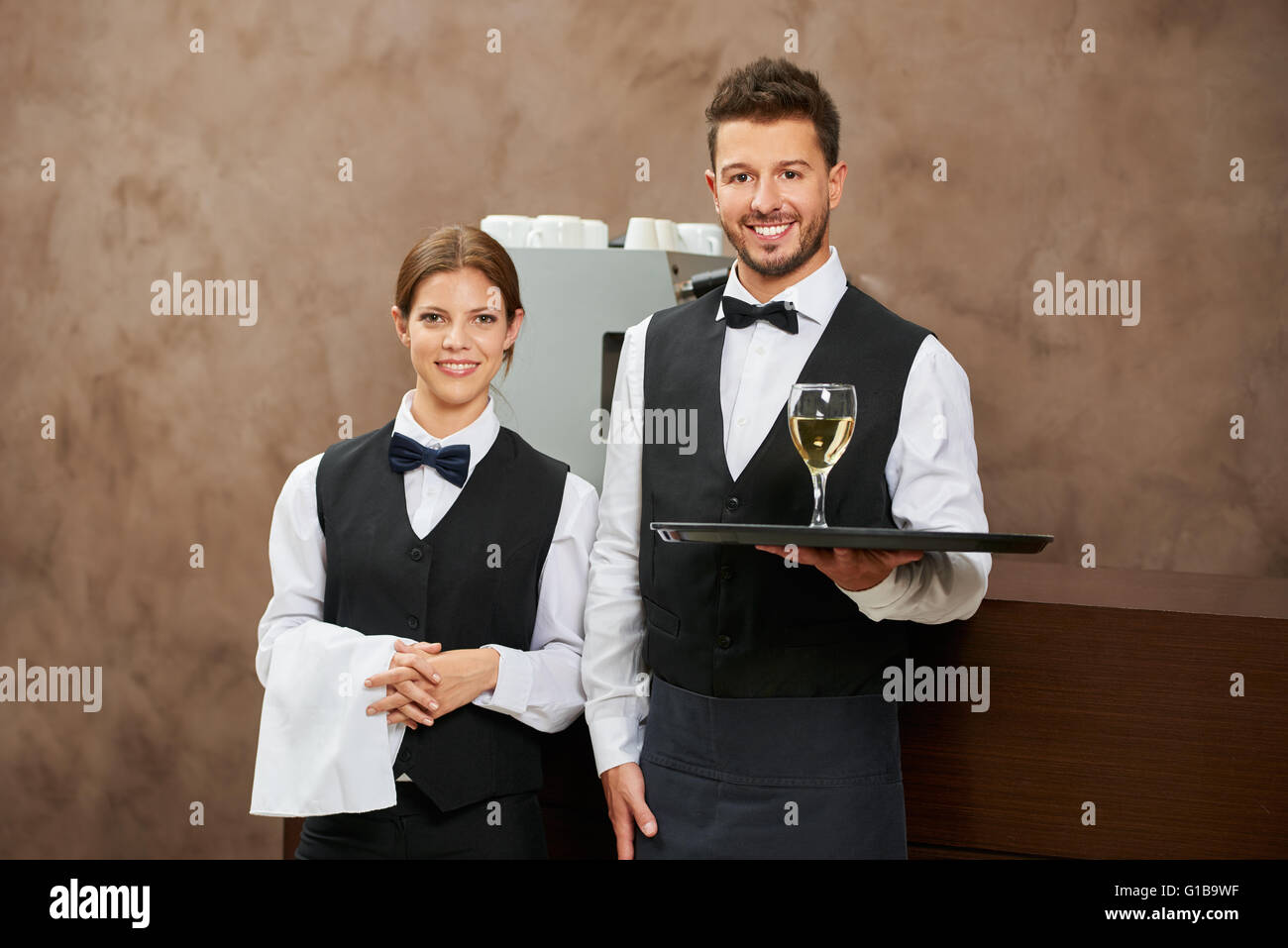 Serveur et serveuse qui sert le vin blanc dans un restaurant de l'hôtel Banque D'Images