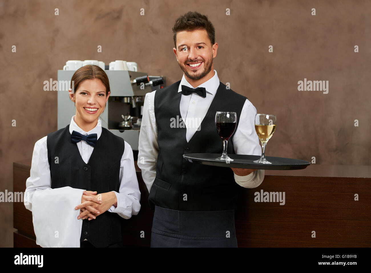 Serveur et serveuse qui sert des boissons dans un restaurant de l'hôtel Banque D'Images Serveur et serveuse qui sert des boissons dans un restaurant de l'hôtel Banque D'Images