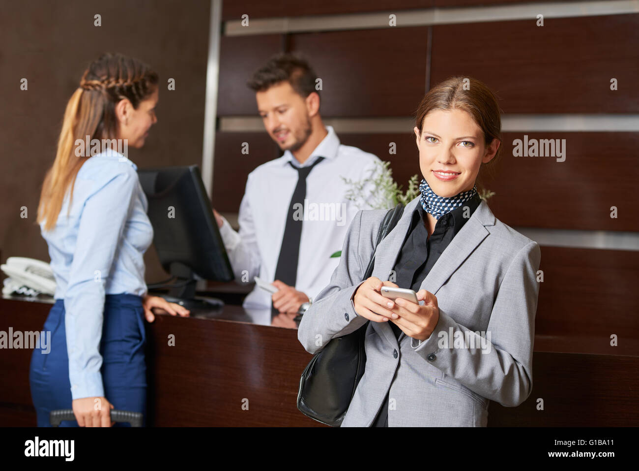 Woman with smartphone à l'arrivée dans un hôtel Banque D'Images