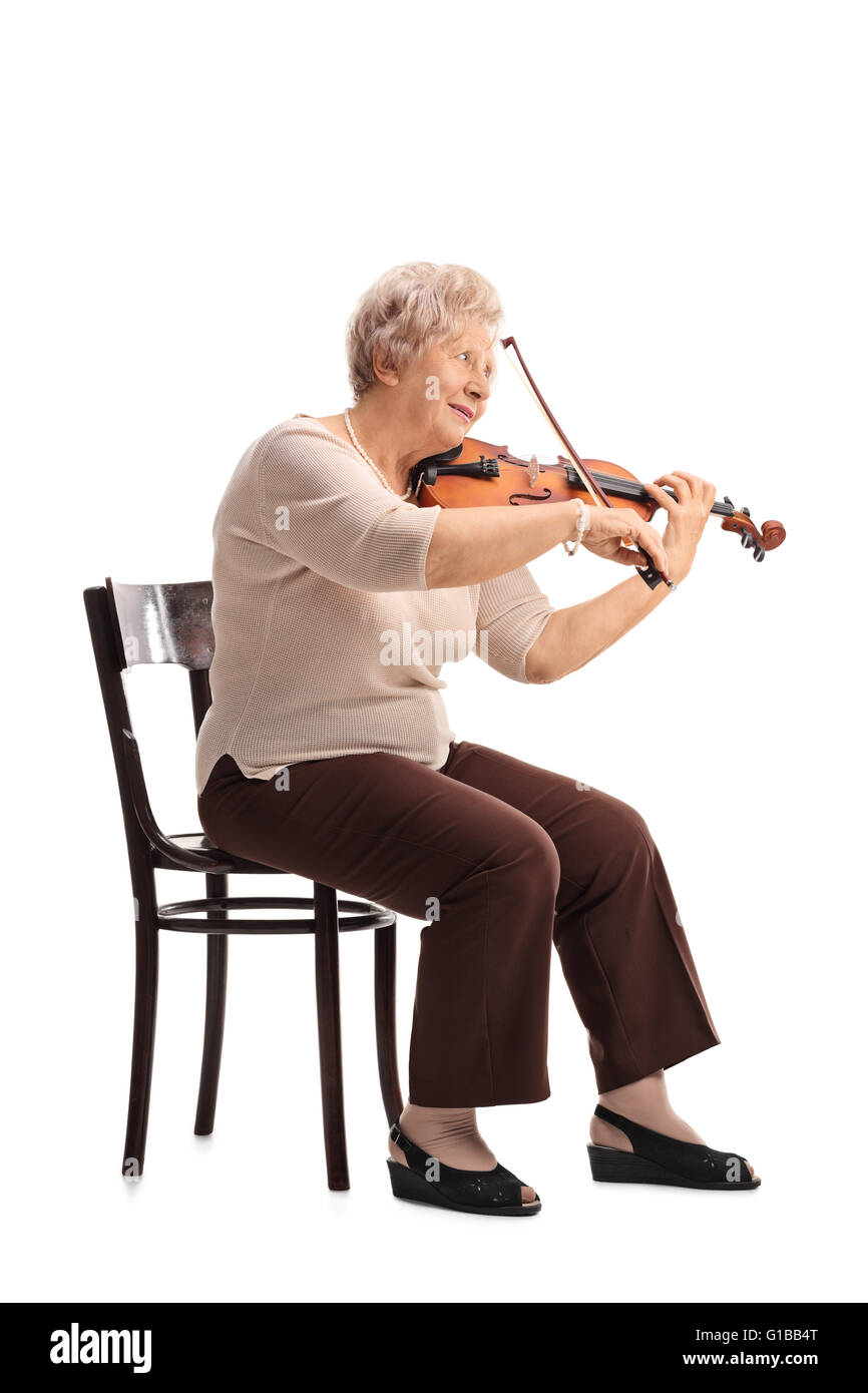 Shot verticale d'une vieille dame jouant du violon assis sur une chaise isolé sur fond blanc Banque D'Images
