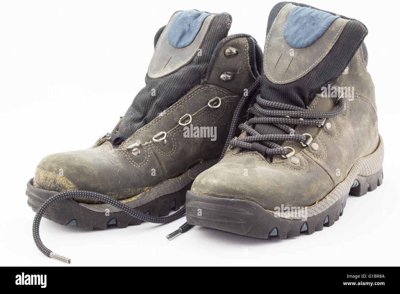 Old weathered et cassé des bottes de randonnée isolé sur fond blanc Banque D'Images