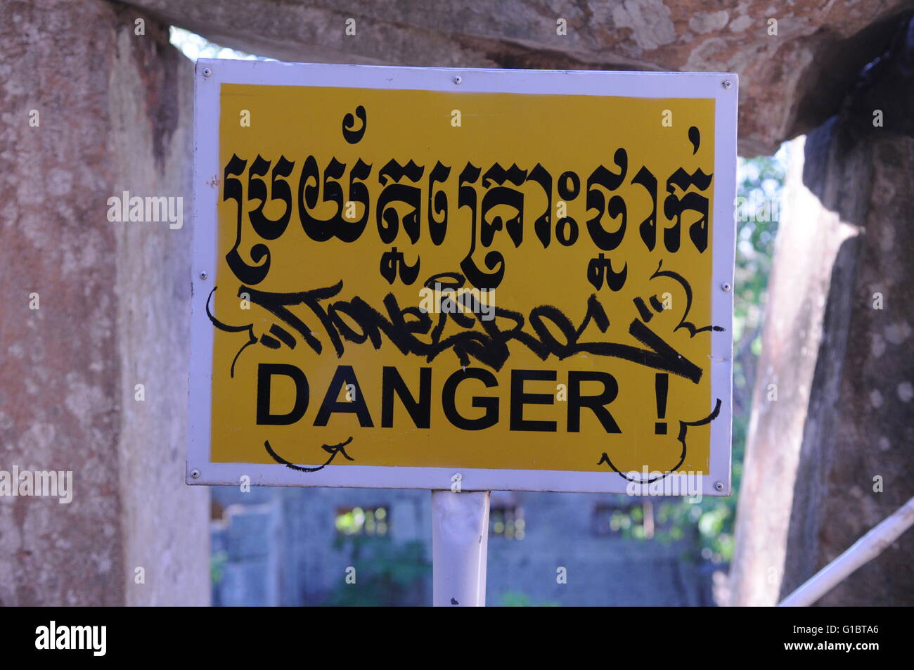 "Danger" bilingue signe en anglais et Khmer, Wat Ek Phnom, Battambang, Cambodge. crédit : Kraig Lieb Banque D'Images