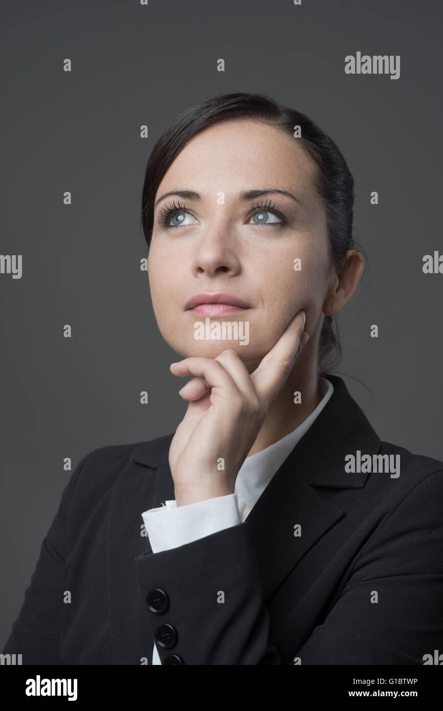 Pensive attrayant business woman with hand on chin à la route. Banque D'Images Pensive attrayant business woman with hand on chin à la route. Banque D'Images