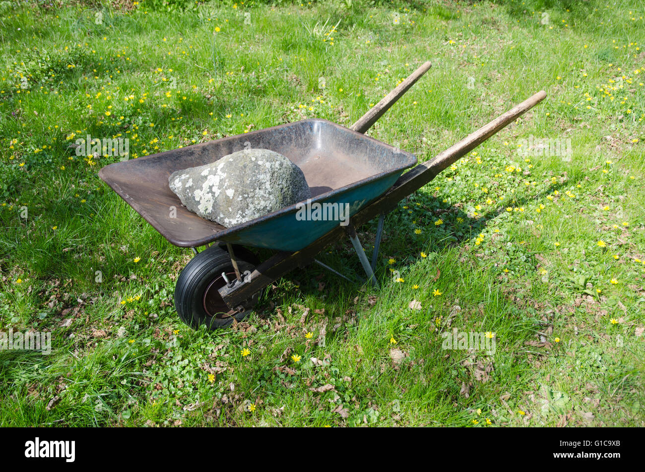 Vieille brouette chargée avec une grosse pierre dans un jardin au printemps  Photo Stock - Alamy