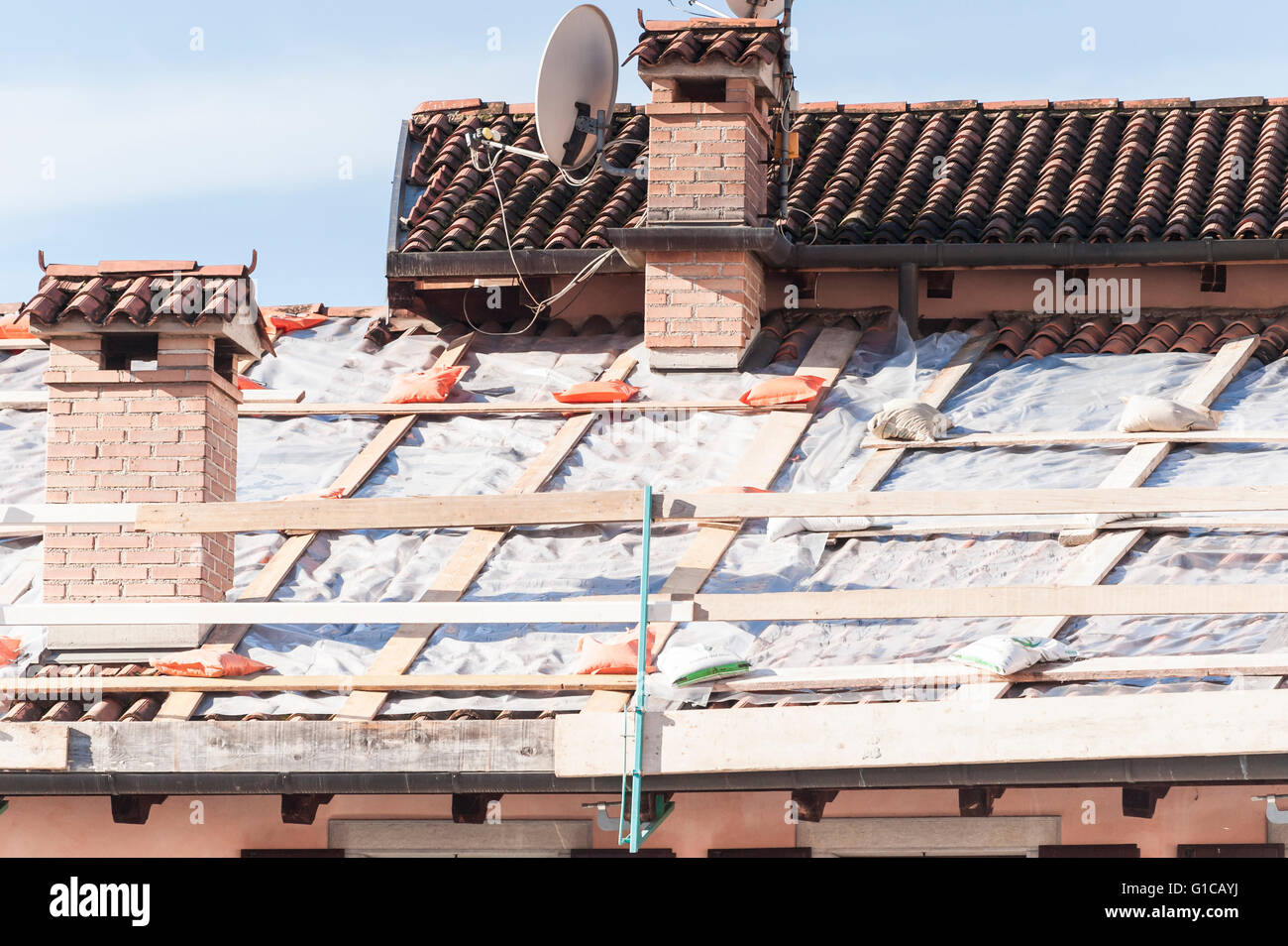 Réparation d'urgence d'un toit avec des feuilles de plastique. Banque D'Images