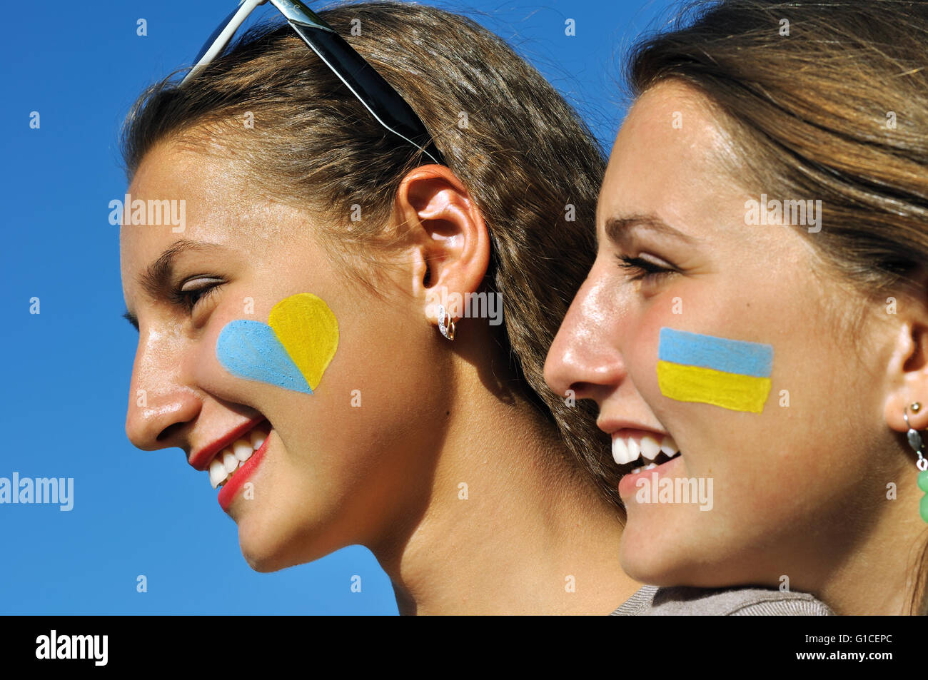 Close-up portrait de deux jeunes filles ukrainiennes peint avec des symboles de l'Ukraine sur les visages Banque D'Images