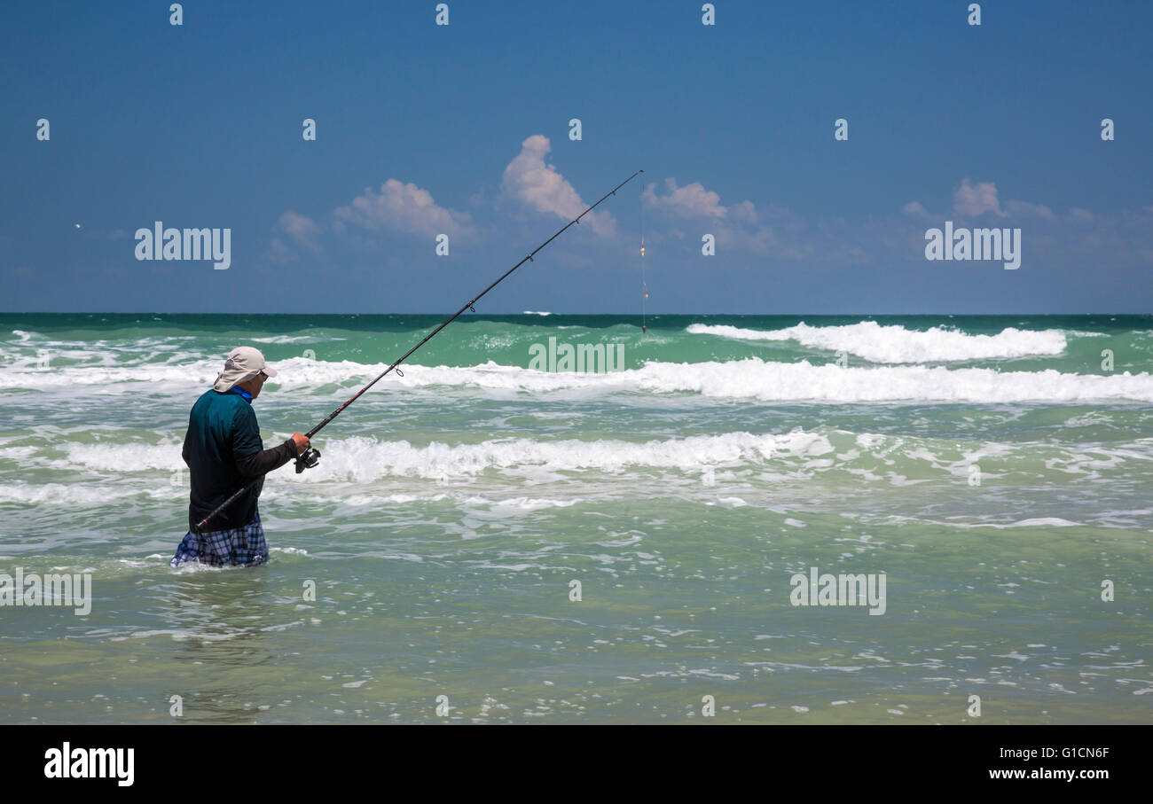 Titusville, Floride - Un pêcheur dans l'Océan Atlantique surf à Canaveral National Seashore. Banque D'Images