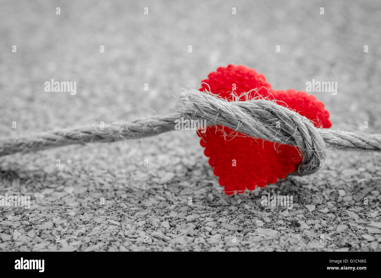 Coeur rouge avec une corde sur un ensemble noir et blanc couleur de bois Banque D'Images