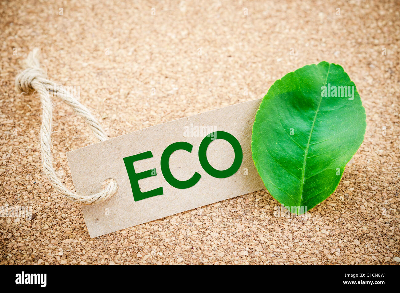 Eco mot sur une étiquette de carton vert, clover leaf, fond en bois Banque D'Images