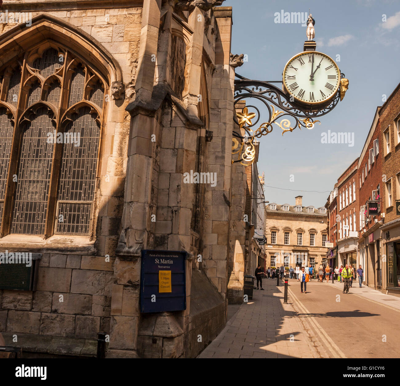 Une vue de la rue Coney occupés dans le centre-ville de York avec les mur suspendu sur l'horloge de l'église St Martins Banque D'Images